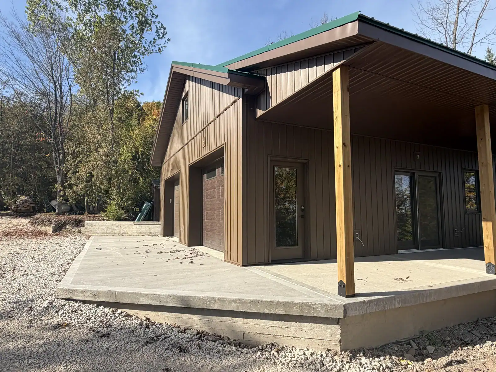 Covered lean-to porch with timber posts on a brown garage