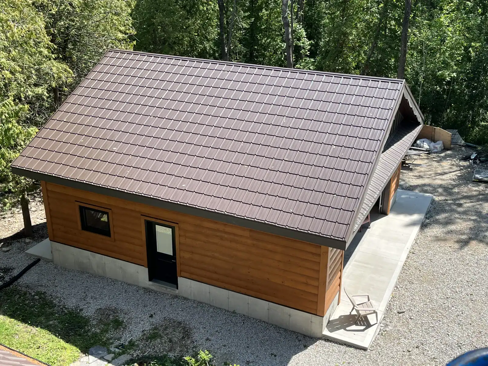 Log-sided outbuilding with brown metal roof