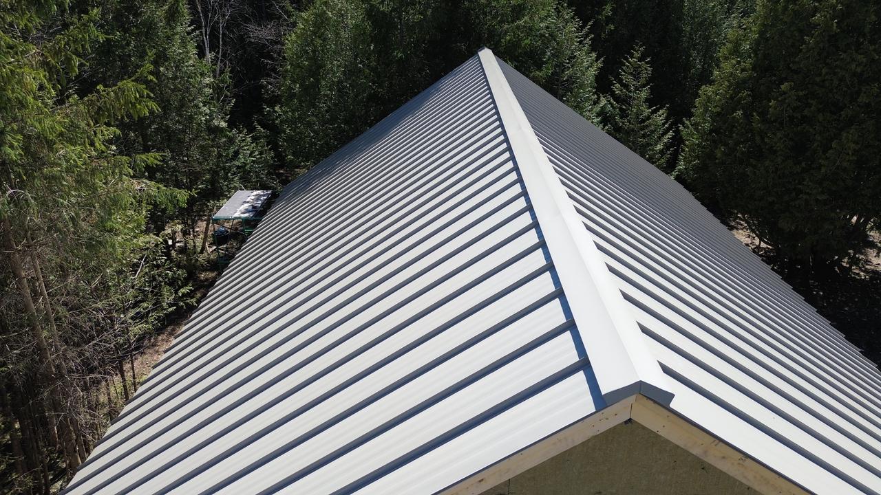Hip ridge of a bone white standing seam roof