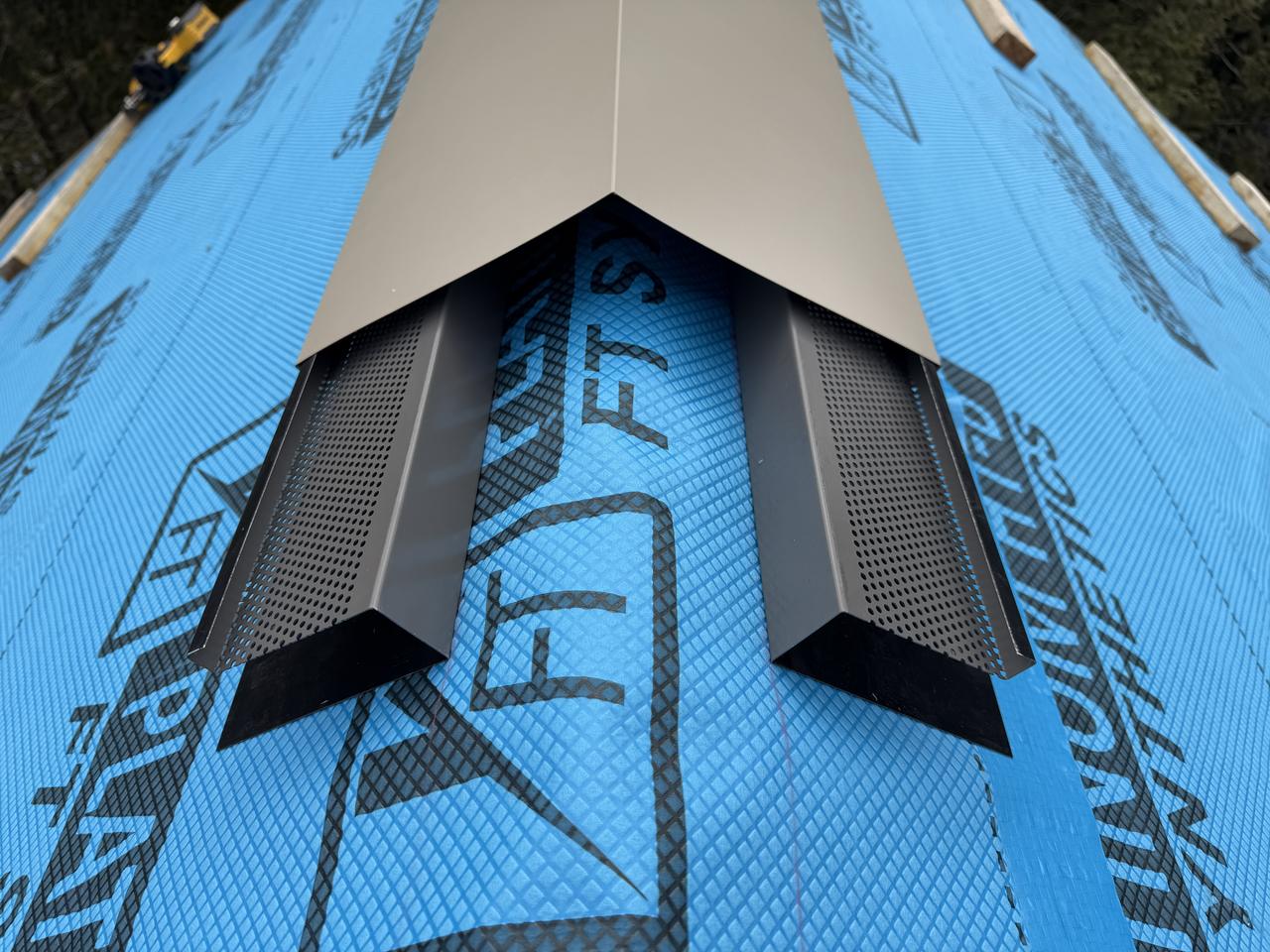 Vented ridge detail with perforated closures before cap installation