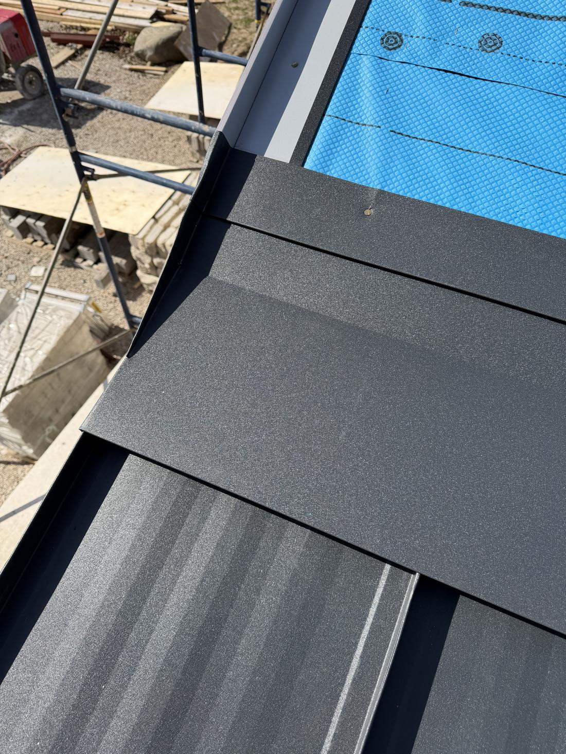 Hip and trim detail on a charcoal standing seam roof