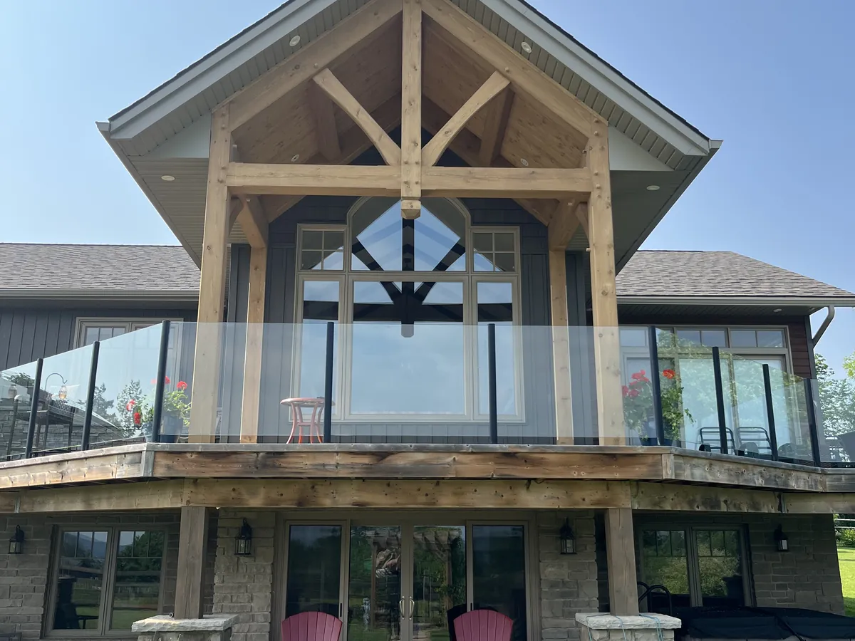 Timber frame great-room gable over a two-storey glass wall and deck