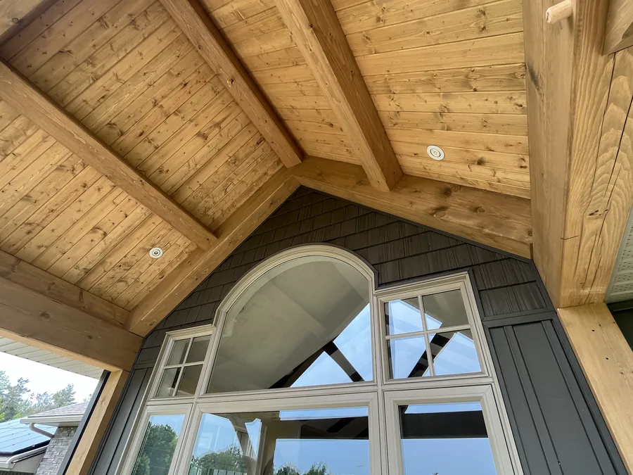 Interior cathedral ceiling framed in timber above an arched window